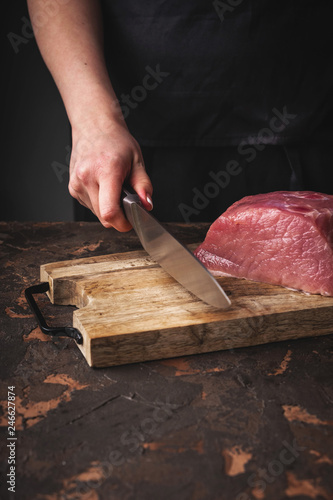 Cuadro en lienzo female hands cut raw pork on a wooden board in the kitchen