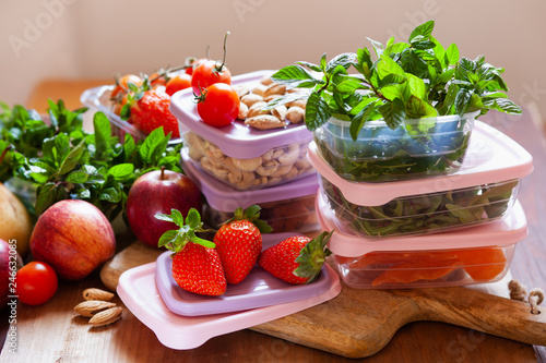 Filled plastic containers to save food  herbs and fruits fresh  concept of economy household