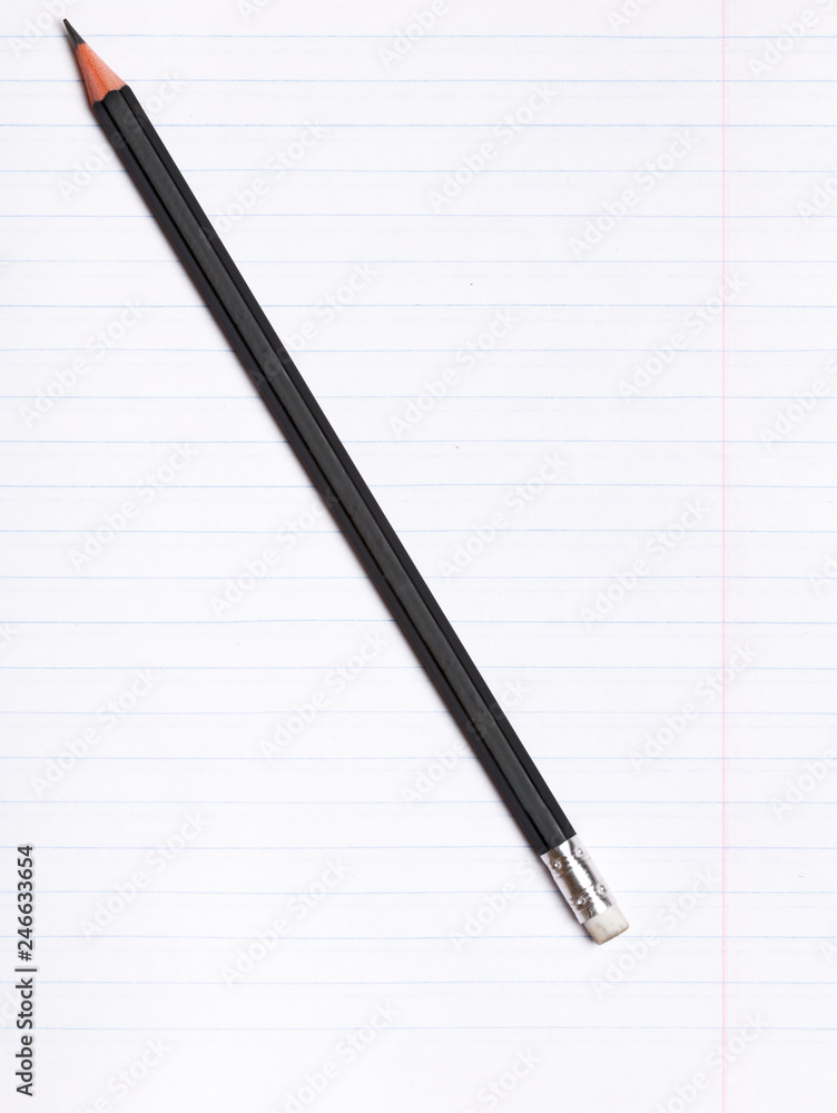 On a sheet of paper notebook with lines lies a black graphite pencil. Copy space. Education concept On a sheet of paper notebook with lines lies a black graphite pencil. Copy space. Education concept