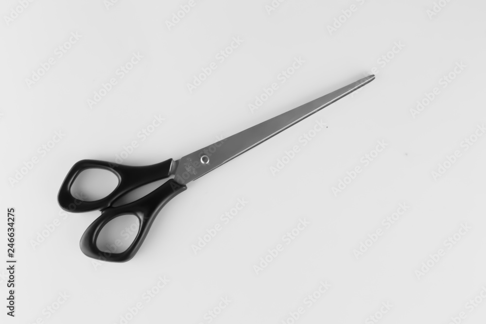 Closed scissors with black rings on a gray background Closed scissors with black rings on a gray background