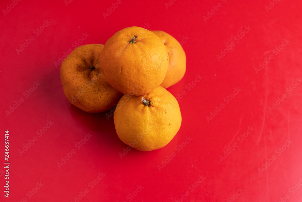 Orange fruits isolated on red background, Lunar Chinese New Year theme concept. Orange fruits isolated on red background, Lunar Chinese New Year theme concept.