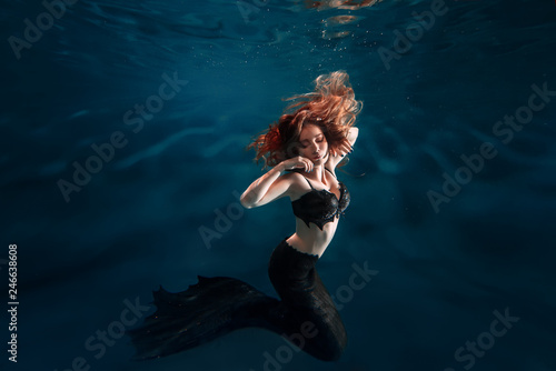 Underwater beautiful red hair freediver girl with mermaid tale