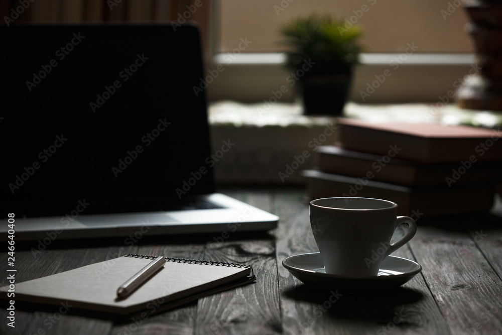 A cup of coffee in the workplace on a wooden table. A cup of coffee in the workplace on a wooden table.