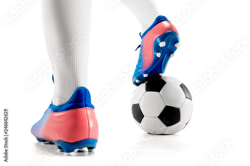 The legs of soccer player close-up isolated on white. Young boy with soccer ball doing flying kick. football soccer player in motion on studio background. Fit boy in action at game.