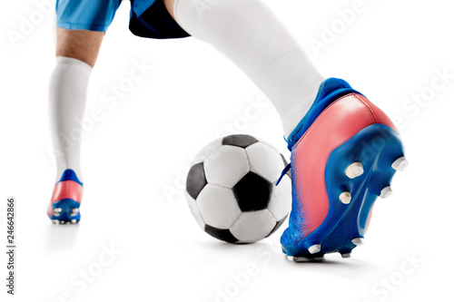 The legs of soccer player close-up isolated on white. Young boy with soccer ball doing flying kick. football soccer player in motion on studio background. Fit boy in action at game.