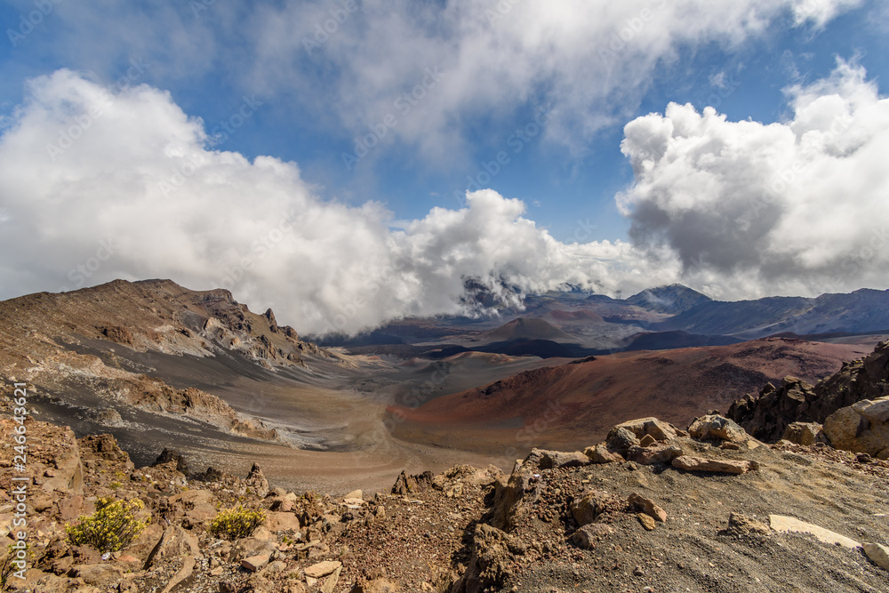 A volcanic crater with a desert-like landscape and blue sky with clouds. Haleakala volcano, Maui, Hawaii.