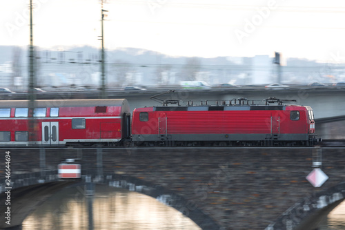 red passenger train speeding on a bridge