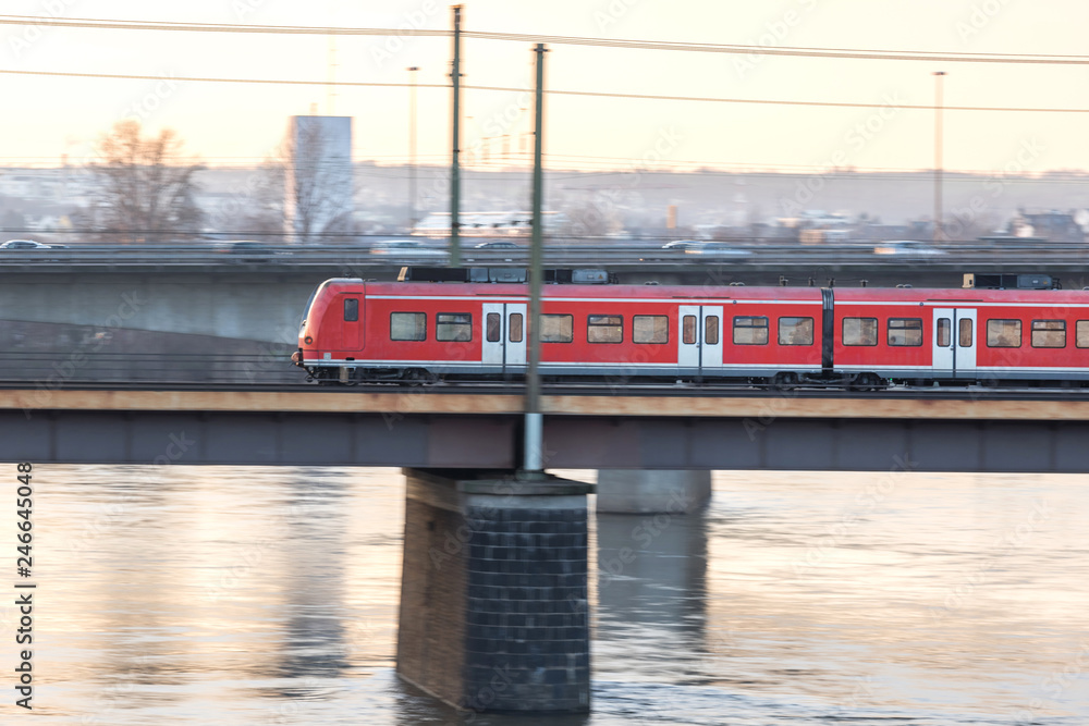 red passenger train speeding on a bridge red passenger train speeding on a bridge