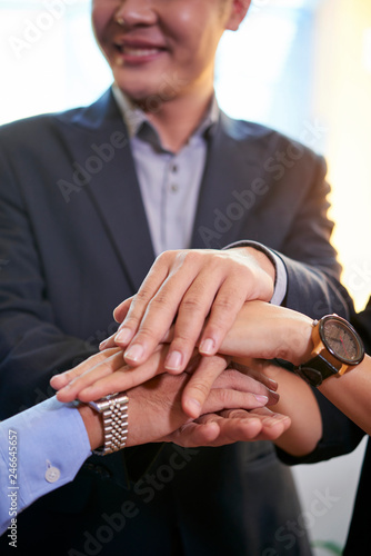 Business executives stacking hands before staring new ambitious project