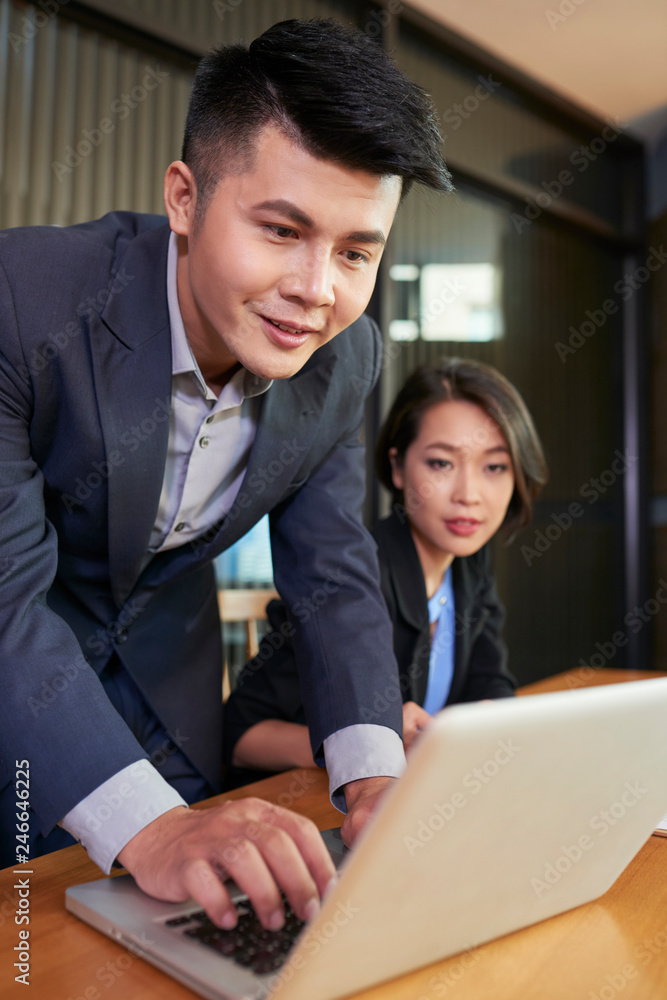 Young Vietnamese business team reading important e-mail from investor Young Vietnamese business team reading important e-mail from investor