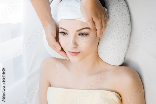 Female with healthy glow perfect smooth skin. Cosmetology, beauty and spa concept. Face massage. Young woman getting spa treatment. Beautiful girl enjoying face massage at beauty salon.