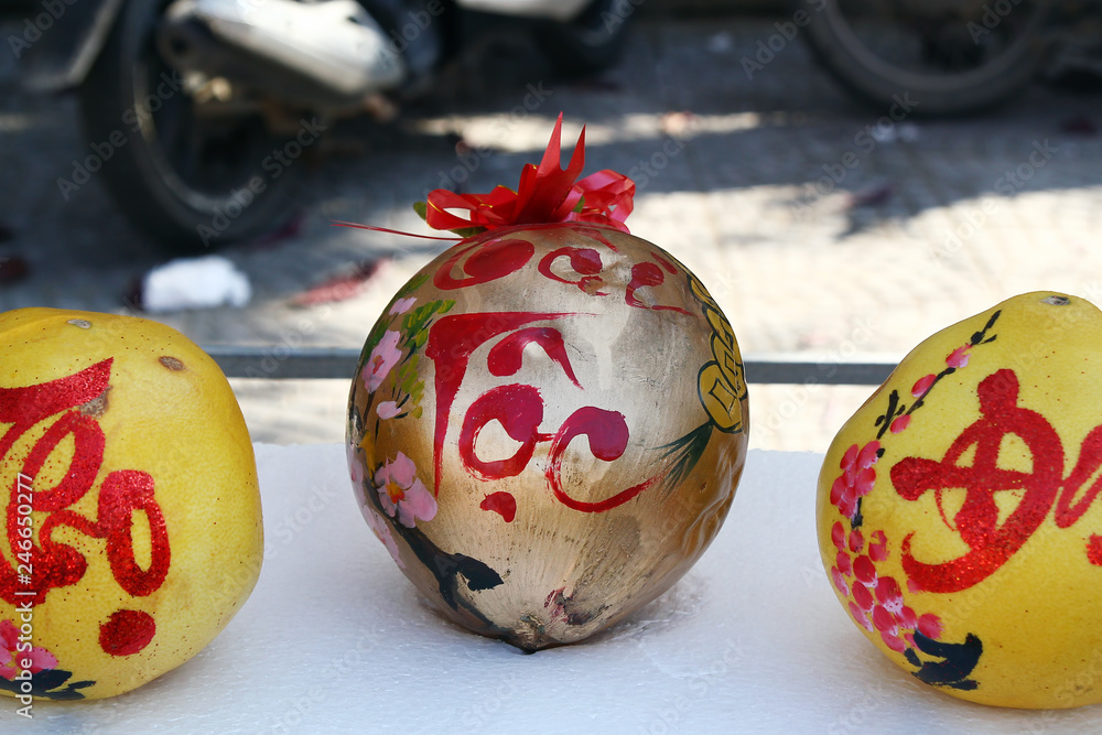Φωτογραφία Three grapefruits decorated for celebration of Vietnamese New Year on a market in Hoi An, Vietnam
