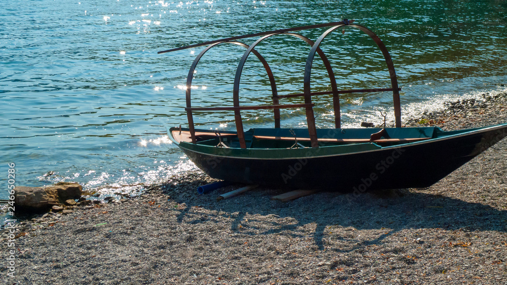Ein altes Boot, Ausflugsschiff liegt am Ufer bei Lenno am comer See