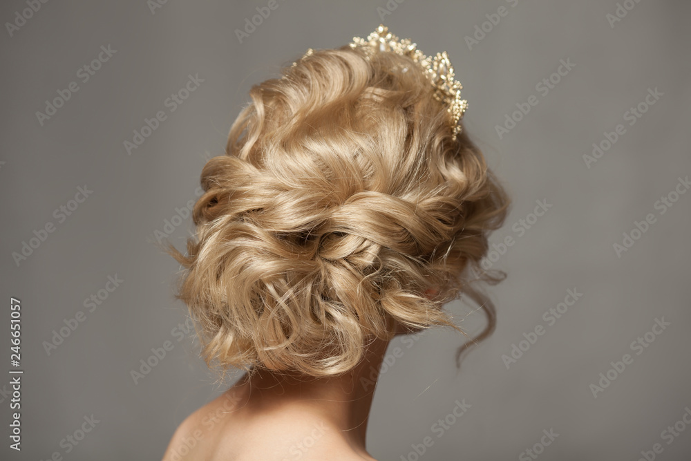 Beautiful blond girl in the image of a bride with a tiara in her hair. Picture taken in the studio on a gray background. Beauty baby face. Wedding image.