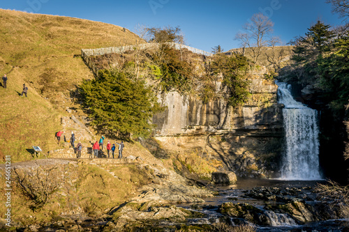 people enjoying the view of a waterfall in Yorkshire, England.  photo