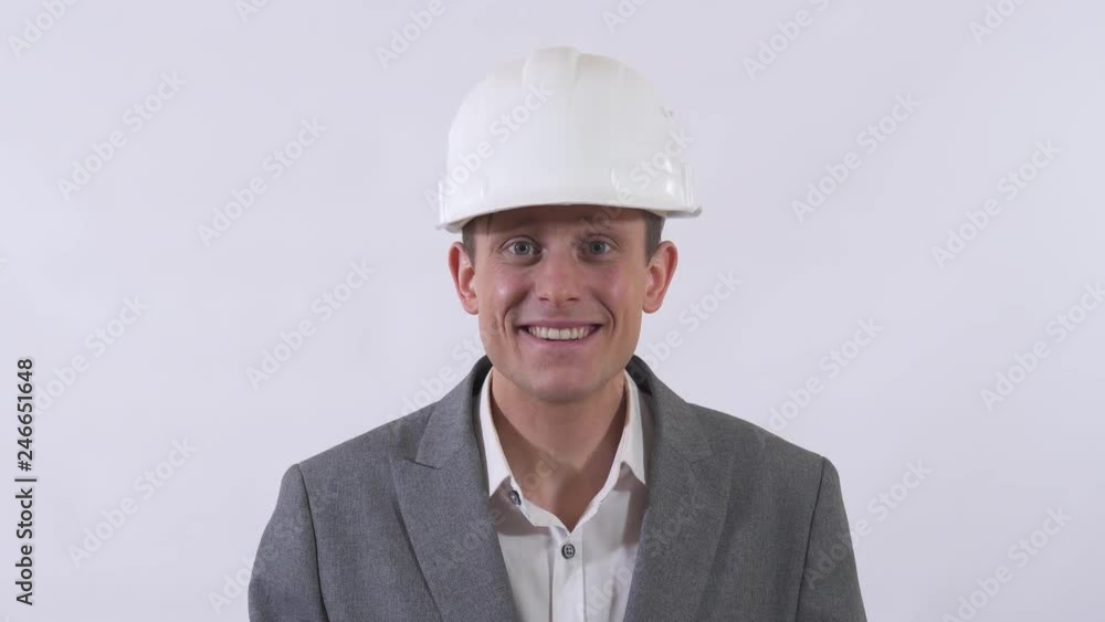 Portrait of pleasant shy man in helmet extends a hand forward holding red rose. Shooting in the studio on a white background. Portrait of pleasant shy man in helmet extends a hand forward holding red rose. Shooting in the studio on a white background.