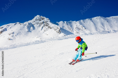 Cute skier boy in a winter ski resort.