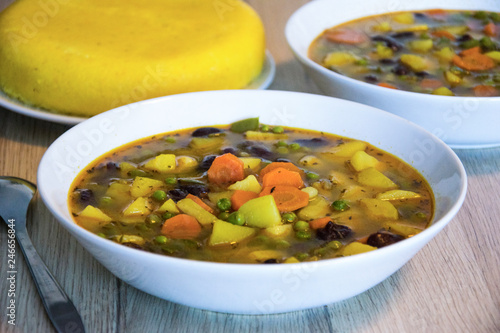 Vegetarian canary bean soup made of canary beans, celery, carrot, potato, tomato, leek, green onions garnished with parsley