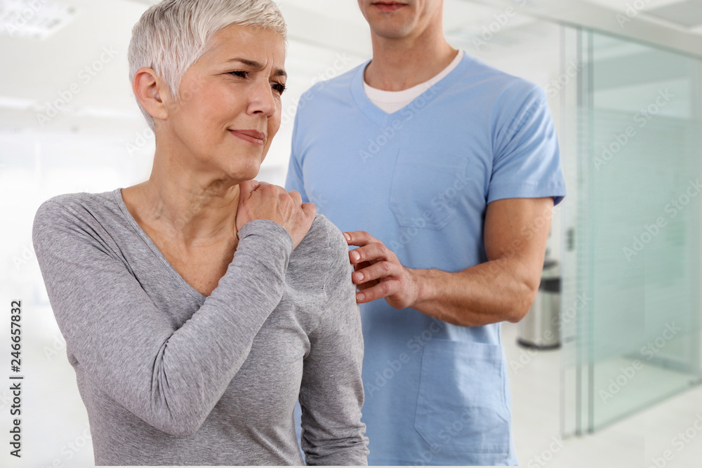 Mature Woman suffering from back pain during medical exam. Chiropractic