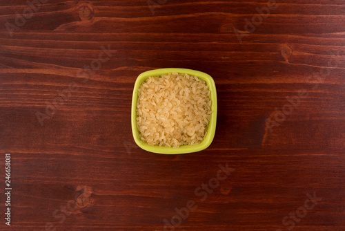 white rice in bowl on wooden table background