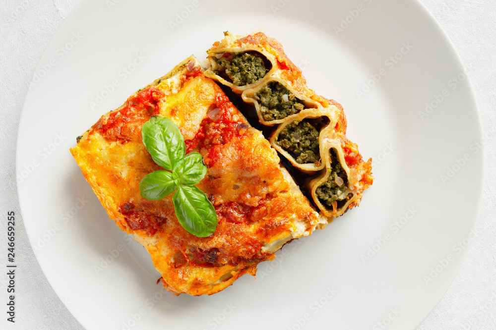 stuffed with beef and spinach cannelloni in tomato and bechamell sauce and decorated with basil leafs stuffed with beef and spinach cannelloni in tomato and bechamell sauce and decorated with basil leafs