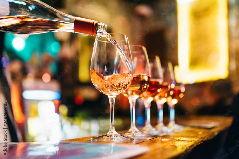 Service Serving Pouring Wine in shiny glasses in bar restaurant night club - obrazy, fototapety, plakaty 