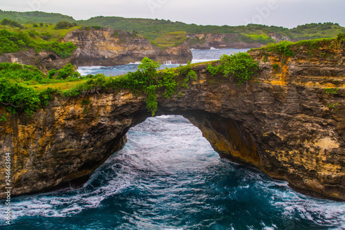 Beautiful view of unique Angels Billabong at Nusa Penida Island, Bali, Indonesia. Turquoise sea water, green grass and vacation mood. Must visit place in Bali.