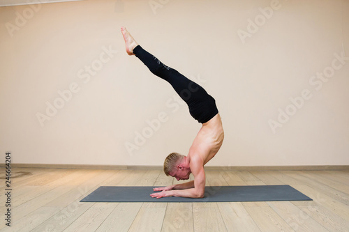 Sporty man practicing yoga on yoga class