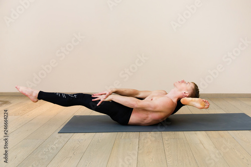 Sporty man practicing yoga on yoga class