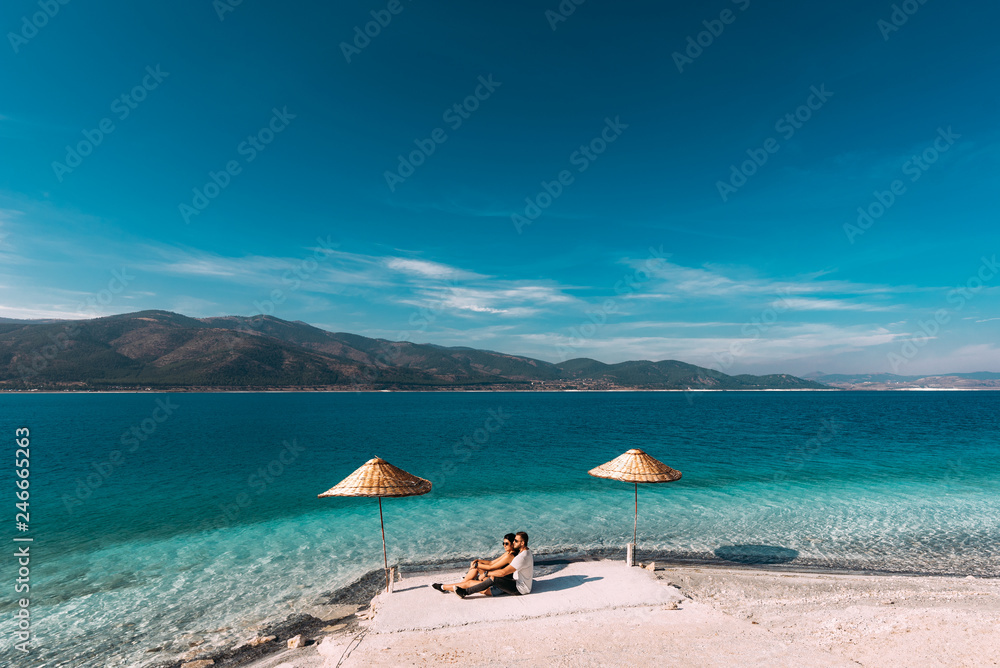 Couple in love in the Blue lagoon. Lovers on the coast. Boy and girl in Turkey. Couple on beach. Man and woman on the island. Couple on vacation. Honeymoon trip. Couple on the lake. Wedding travel Couple in love in the Blue lagoon. Lovers on the coast. Boy and girl in Turkey. Couple on beach. Man and woman on the island. Couple on vacation. Honeymoon trip. Couple on the lake. Wedding travel