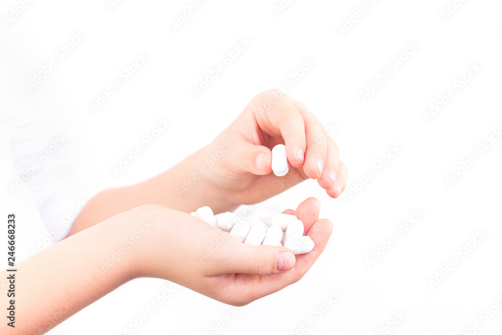 Two kid's hands and handful of white tablets, drugs and medicine safety and consumption concept with copy space Two kid's hands and handful of white tablets, drugs and medicine safety and consumption concept with copy space