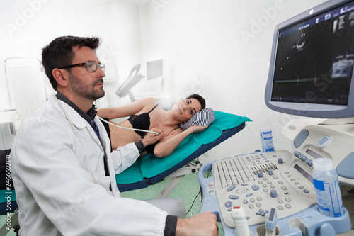 A doctor listening his female patient with a ultrasound ecography photo