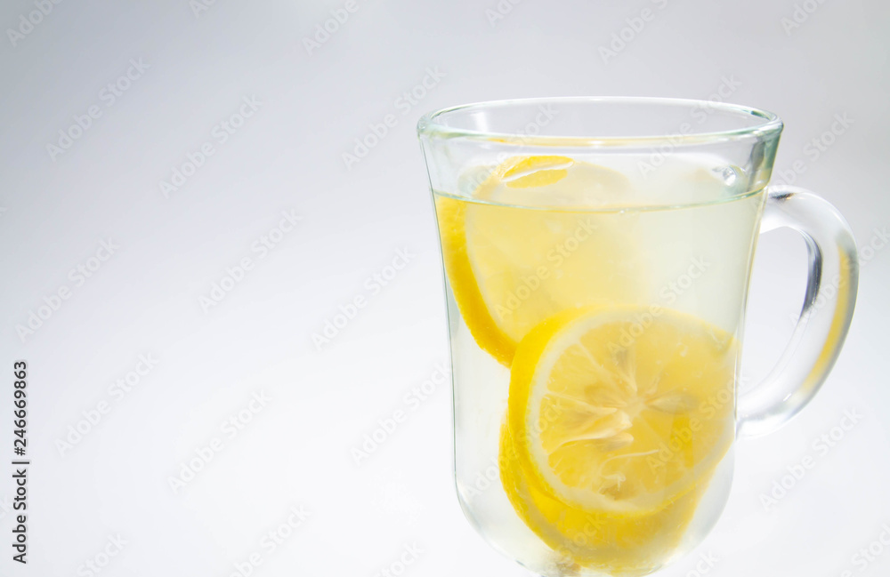 lemon tea in a clear glass Cup close on a light background