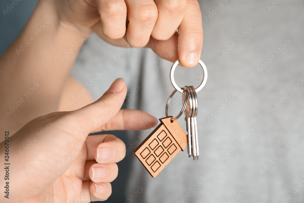 Fototapeta premium Man giving house key with trinket to woman, closeup