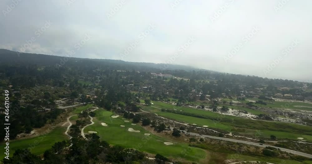 Golf course on overcast day with mountains in background - aerial shot Golf course on overcast day with mountains in background - aerial shot