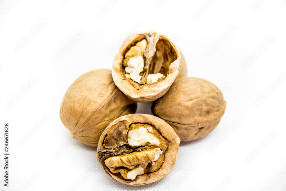 a few walnut in shell and peeled on white background a few walnut in shell and peeled on white background