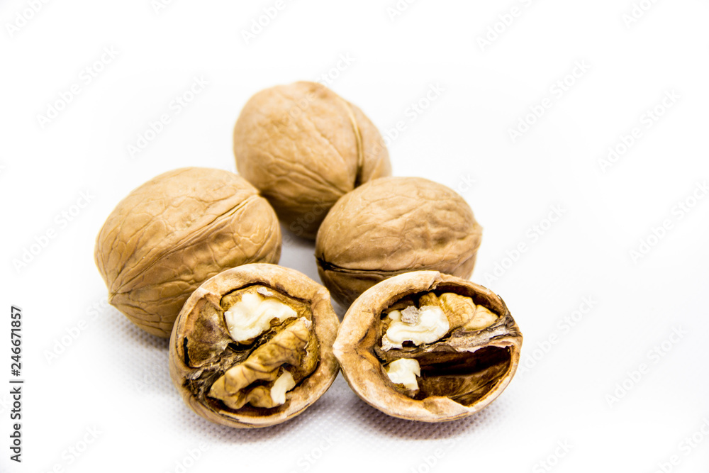 a few walnut in shell and peeled on white background a few walnut in shell and peeled on white background