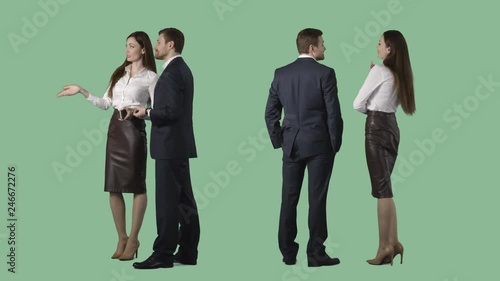 Business man and elegant female are standing, looking at something, discussing. Cut out on alpha channel background