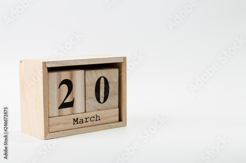 Wooden calendar March 20 on a white background