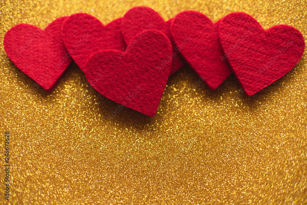 Red felt hearts on golden shiny background. Valentine's Day Red felt hearts on golden shiny background. Valentine's Day