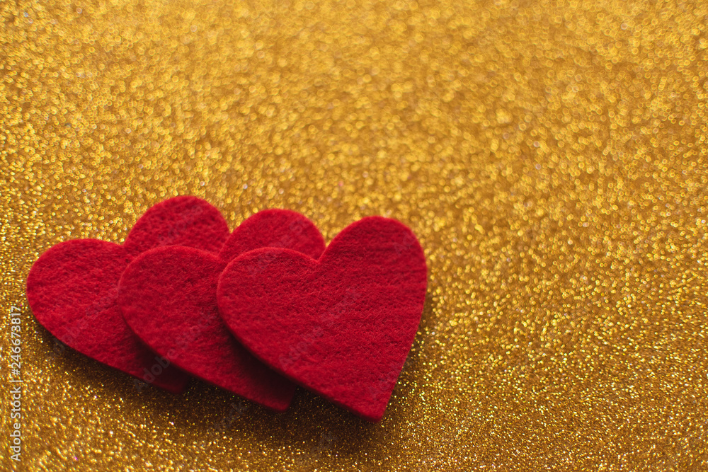 Red felt hearts on golden shiny background. Valentine's Day Red felt hearts on golden shiny background. Valentine's Day