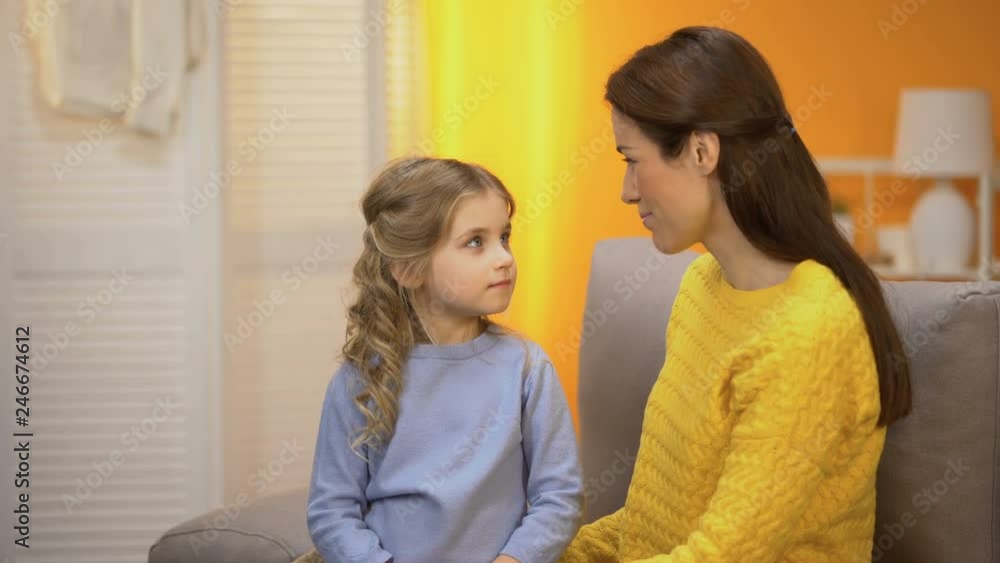 Young mother stroking little girls hair and hugging her, happiness in family Young mother stroking little girls hair and hugging her, happiness in family