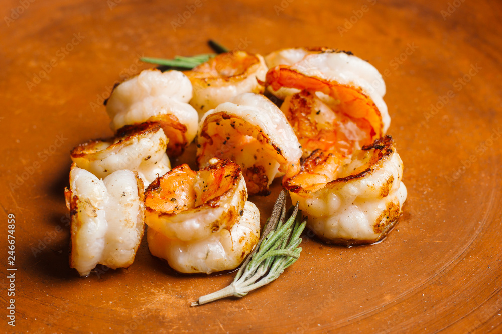 Grilled tiger shrimps with spice on a clay plate.