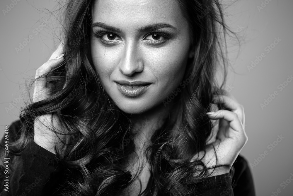 Brunette girl with healthy curly hair and natural make up . Beautiful model woman with wavy hairstyle .Care and beauty Brunette girl with healthy curly hair and natural make up . Beautiful model woman with wavy hairstyle .Care and beauty