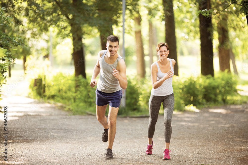Young man and young woman jogging together outdoors