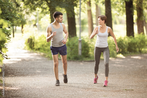 Young man and young woman jogging together in park