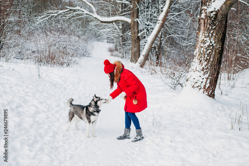Young woman playing with her Husky dog in winter park © Elena Kratovich