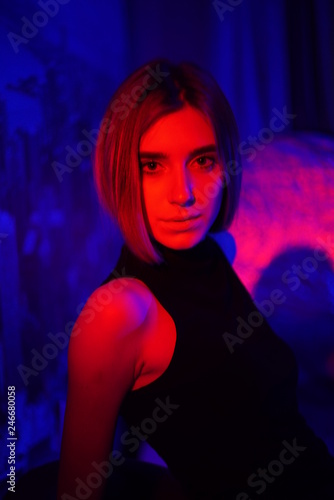 Sexy young beauty woman posing over night city dramatic red and blue neon background