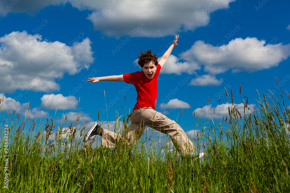 Boy jumping, running against blue sky Boy jumping, running against blue sky