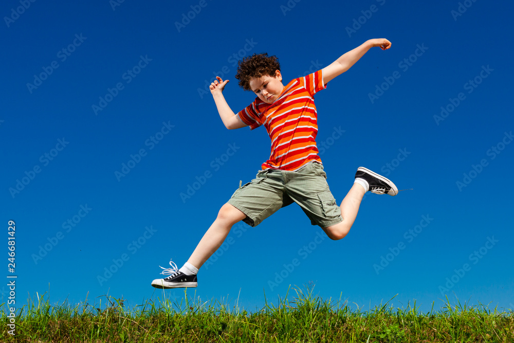 Boy jumping, running against blue sky Boy jumping, running against blue sky